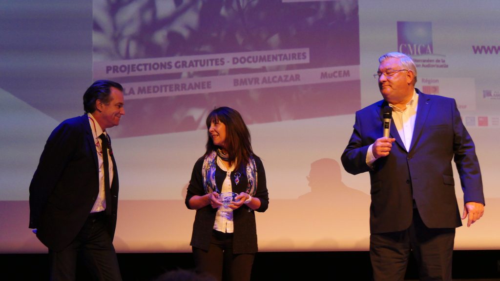 Ithri Irhoudane, entourée de Renaud Muselier et de Daniel Deloit, membre du jury, reçoit le Prix Art, patrimoine et Cultures pour "Tisseuses de rêves"